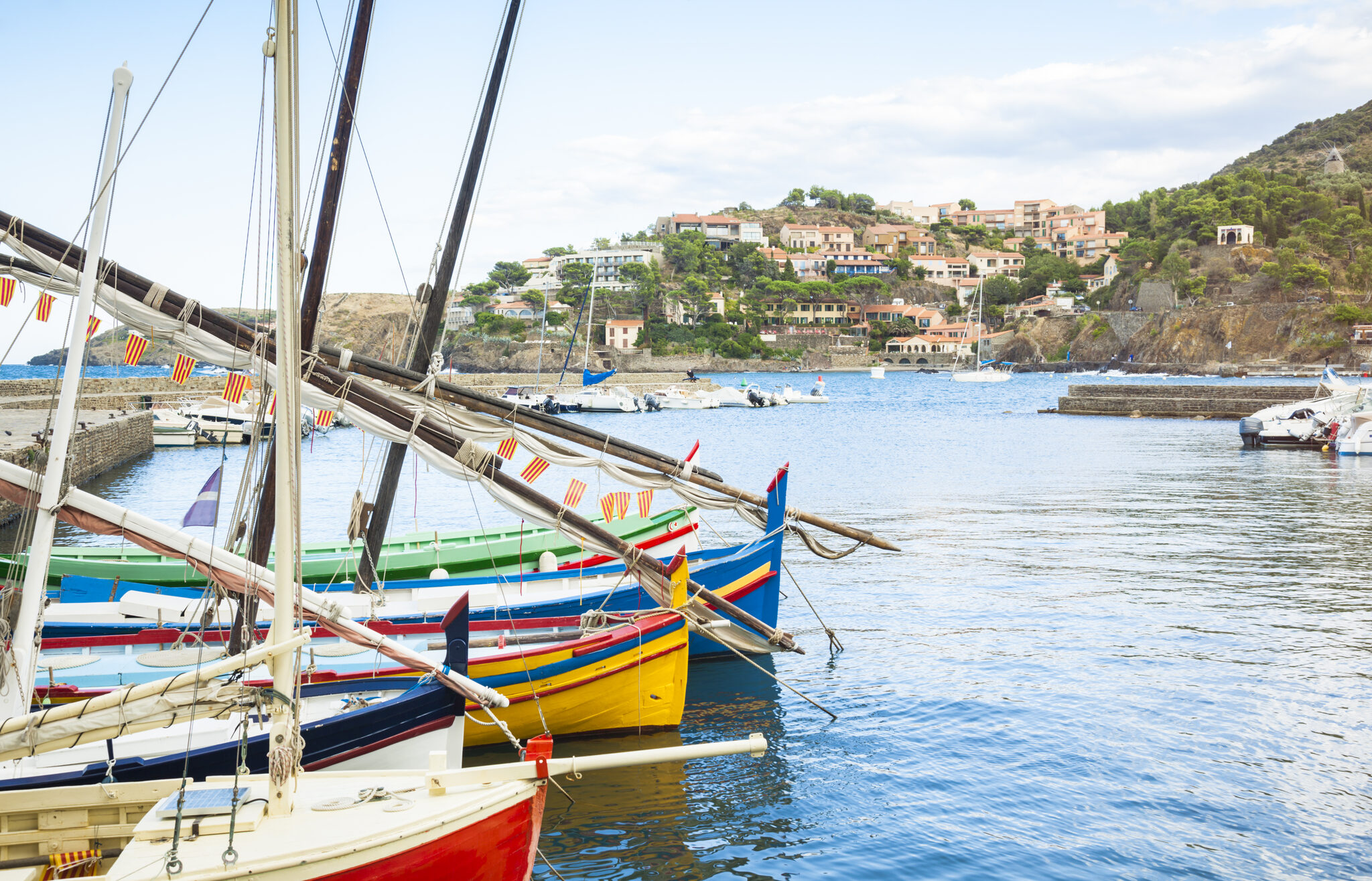 Bateaux colorés au port, village d’Argelès-sur-Mer et collines en arrière-plan.