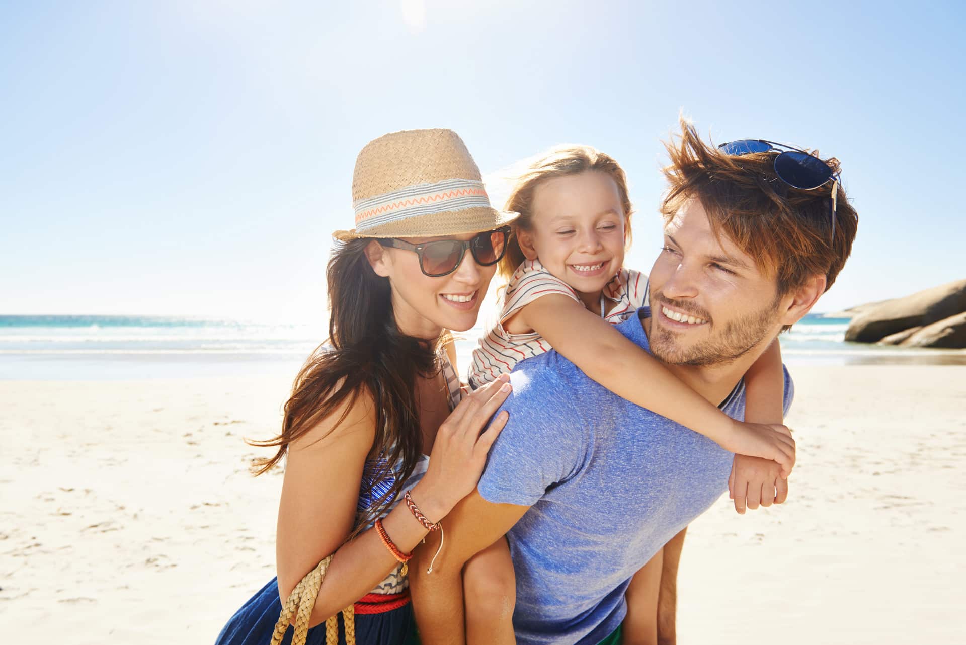 Famille souriante sur la plage, vacances Arlequin.